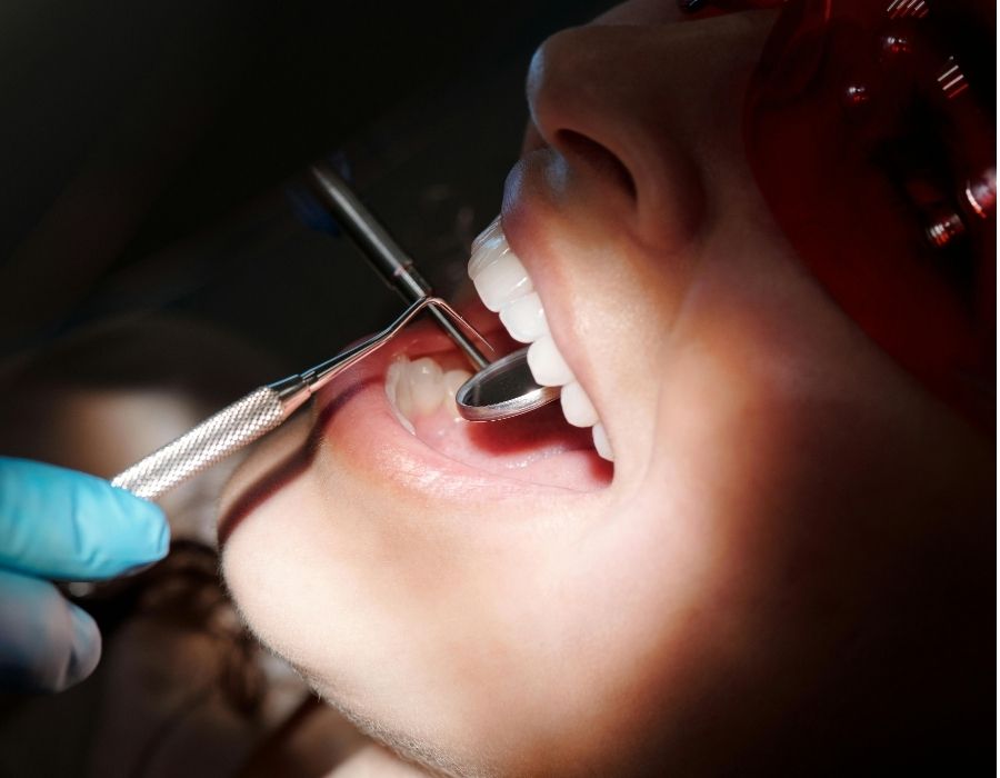 Dental check-up with oral examination tools inspecting patient’s teeth