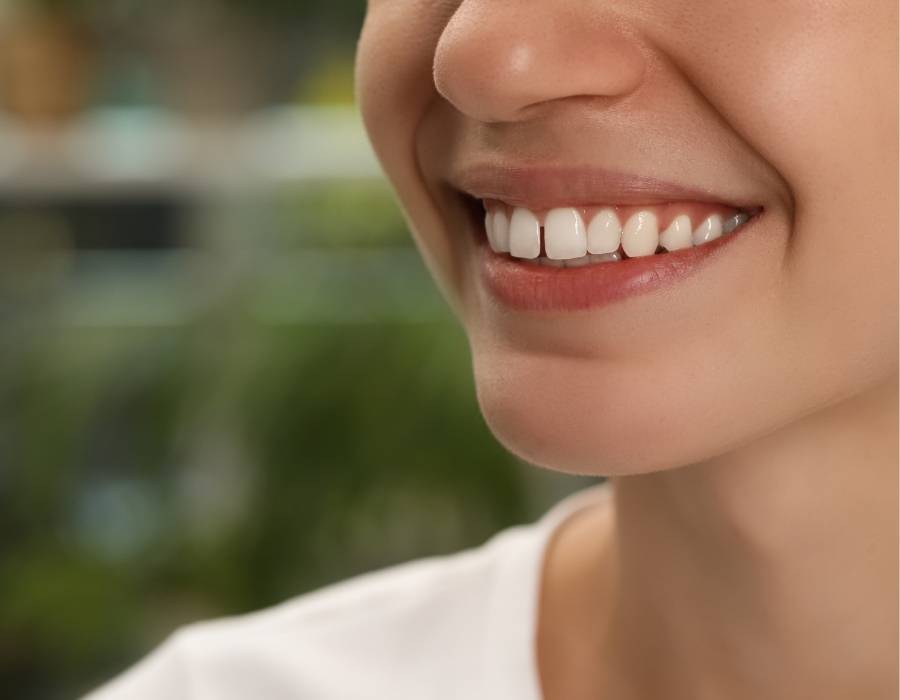 Close-up of a woman smiling with a slight gap between her front teeth, a condition known as diastema, often addressed through orthodontic treatment.